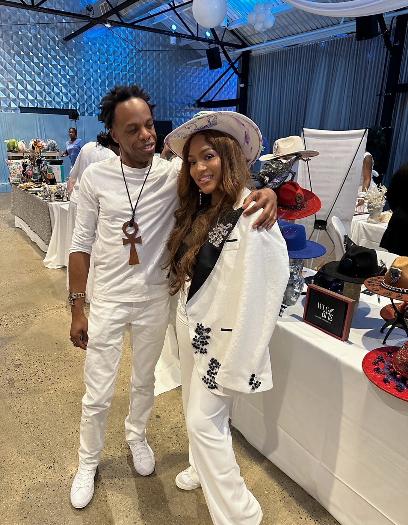 Stylish duo in white outfits at exhibit.